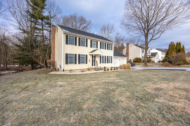 colonial house featuring a front lawn and a garage