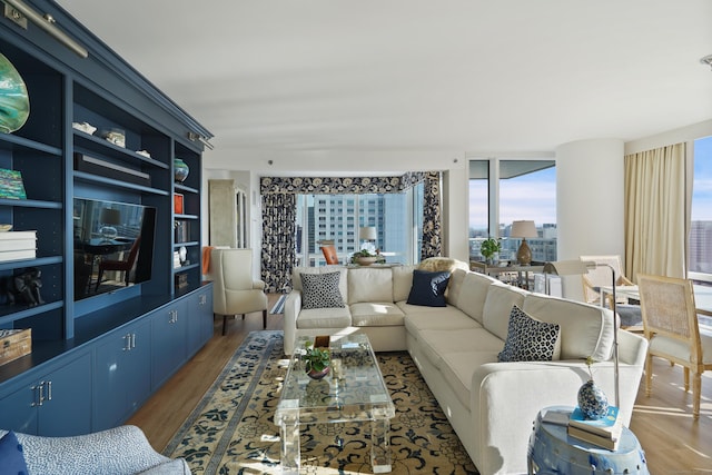 living room featuring a wall of windows and light hardwood / wood-style flooring