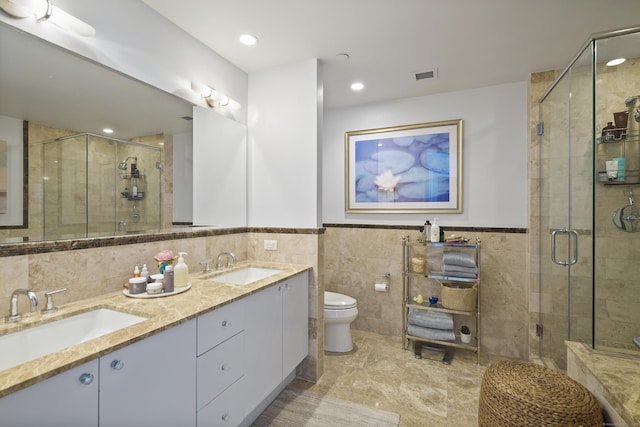 bathroom featuring toilet, tile walls, a shower with door, and vanity