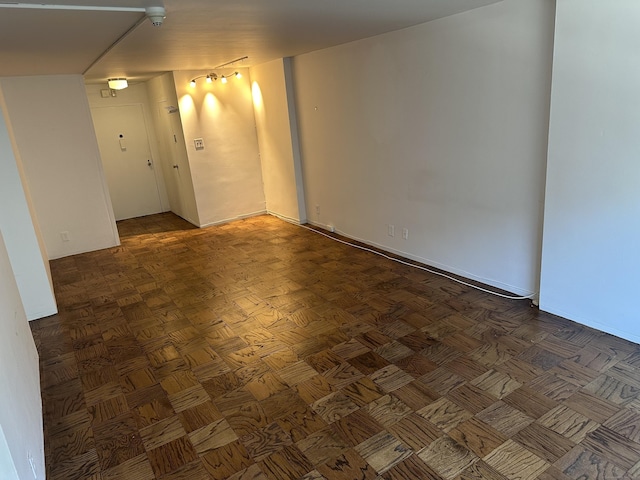 unfurnished room with dark parquet flooring