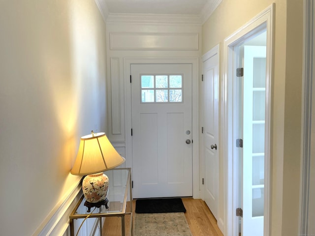 entryway with crown molding and light wood-type flooring