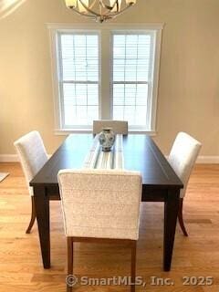 145 Webster Ln Unit 2-41, Middletown, CT 06457 - dining area featuring baseboards, a wealth of natural light, wood finished floors, and a notable chandelier