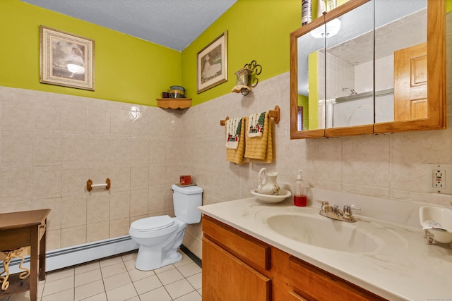 bathroom featuring a textured ceiling, tile patterned flooring, a baseboard heating unit, vanity, and tile walls