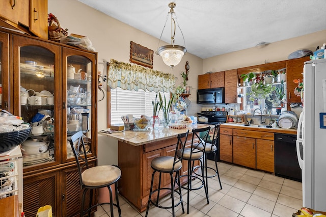 kitchen featuring a wealth of natural light, light tile patterned floors, and black appliances