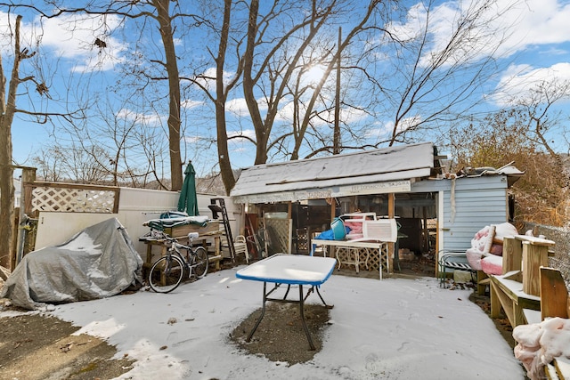 snow covered patio with an outbuilding