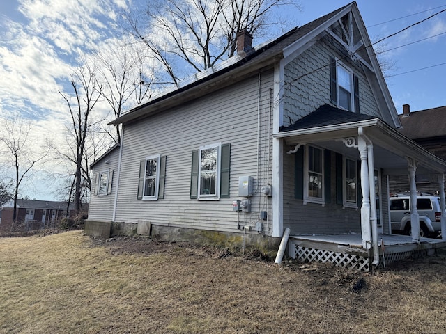 view of property exterior featuring a yard and a porch