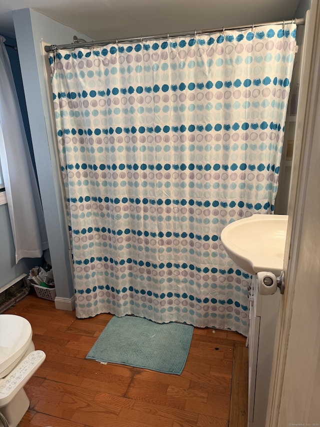 bathroom featuring toilet and wood-type flooring