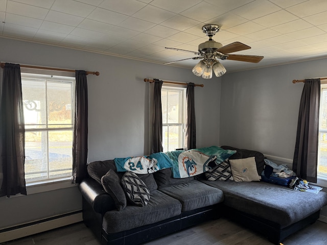 living room featuring baseboard heating, hardwood / wood-style floors, and ceiling fan