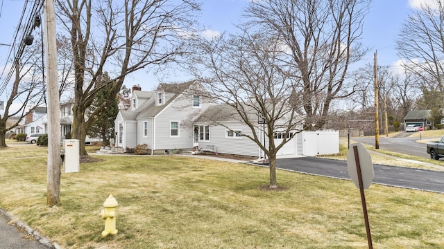 cape cod home featuring a front yard