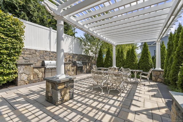 view of patio / terrace featuring grilling area, a pergola, and an outdoor kitchen