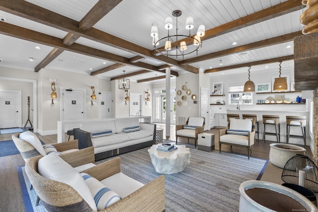 living room with hardwood / wood-style floors, beam ceiling, and an inviting chandelier