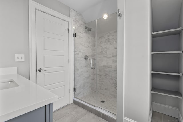 bathroom featuring a shower with shower door, vanity, and tile patterned flooring