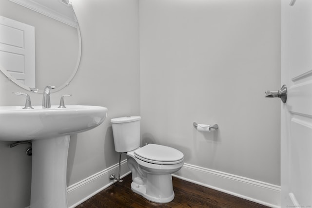 bathroom with hardwood / wood-style floors, toilet, and ornamental molding