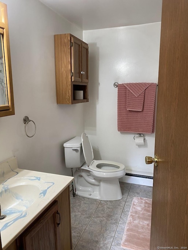 bathroom with toilet, tile patterned floors, vanity, and a baseboard radiator