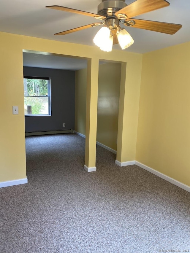 carpeted empty room with ceiling fan and a baseboard heating unit