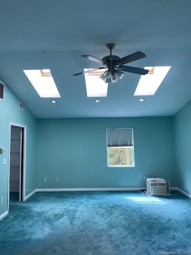 bonus room featuring ceiling fan, vaulted ceiling with skylight, dark carpet, and a wall mounted AC