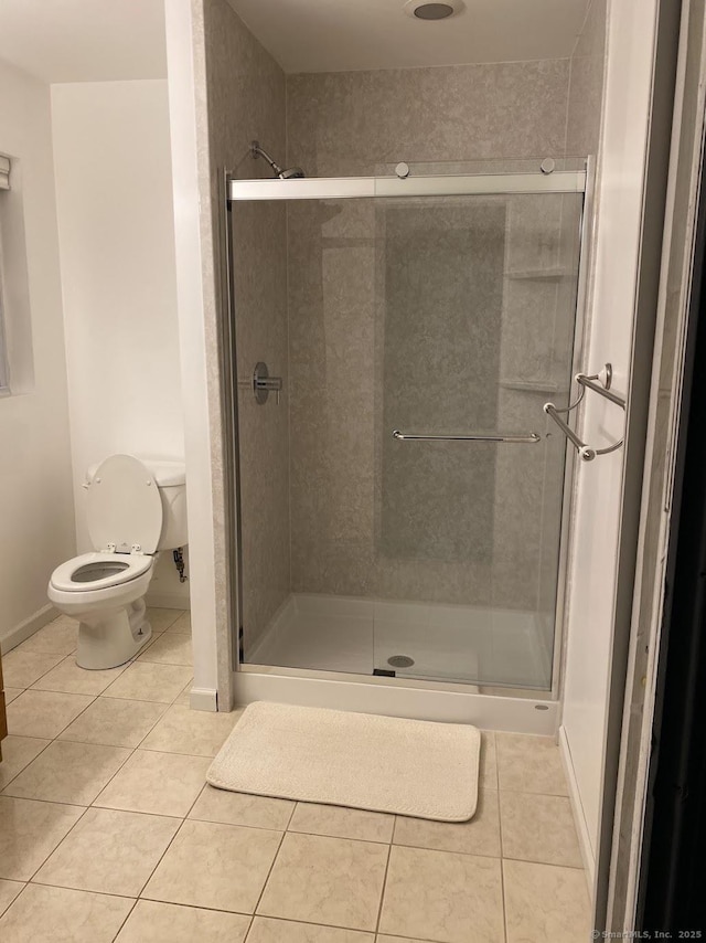 bathroom featuring toilet, tile patterned floors, and walk in shower