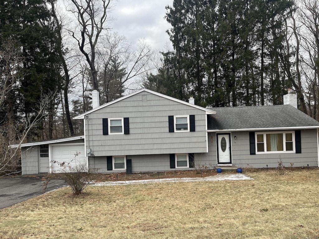 tri-level home with a front lawn and a garage