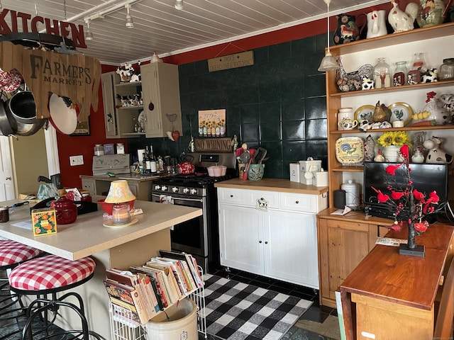 kitchen with a center island, ornamental molding, gas range, and a kitchen breakfast bar