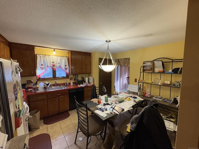 kitchen with black dishwasher, light tile patterned flooring, hanging light fixtures, stainless steel refrigerator, and a textured ceiling