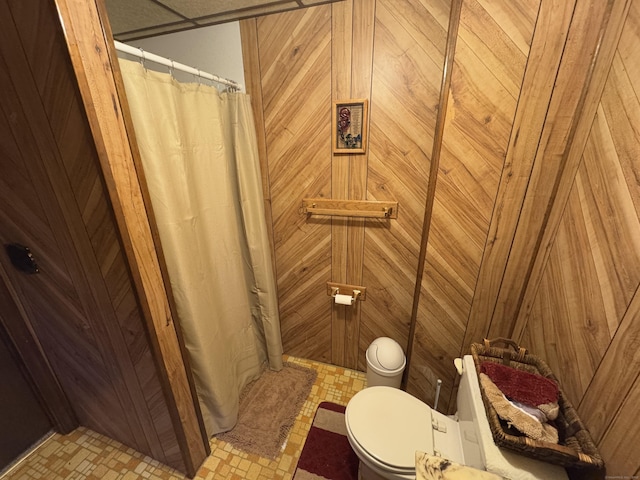 bathroom featuring toilet and wooden walls