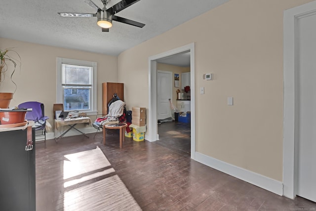 sitting room featuring a textured ceiling, ceiling fan, and dark hardwood / wood-style flooring