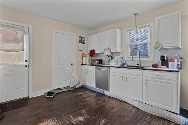 kitchen featuring pendant lighting, dishwasher, white cabinetry, decorative backsplash, and sink