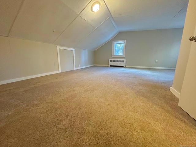 bonus room featuring vaulted ceiling, carpet floors, radiator heating unit, and baseboards