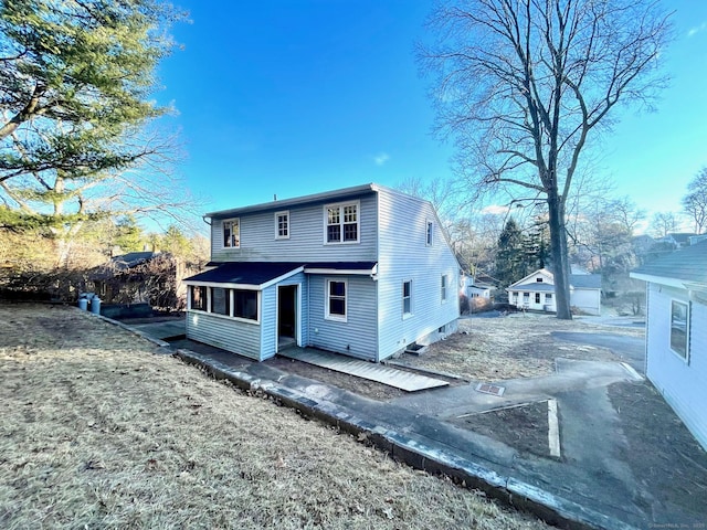 back of property with a sunroom