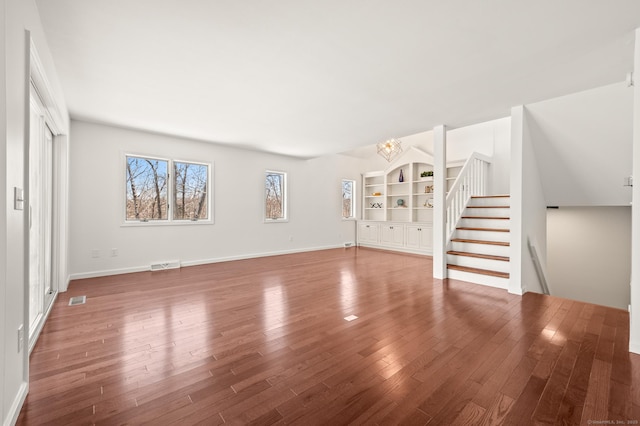 unfurnished living room featuring hardwood / wood-style floors and an inviting chandelier