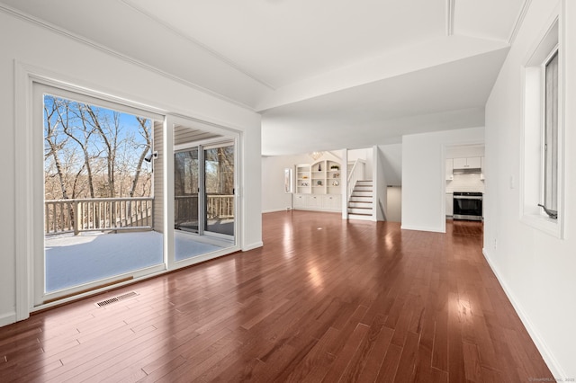 unfurnished living room with ornamental molding and dark hardwood / wood-style flooring