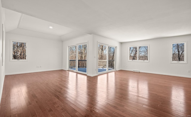 unfurnished living room featuring vaulted ceiling and hardwood / wood-style floors