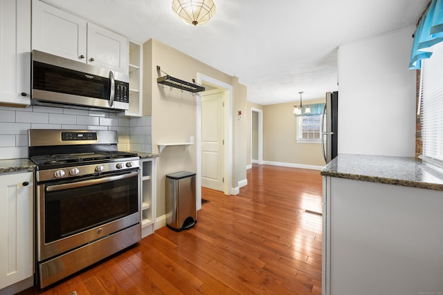 kitchen featuring white cabinets, decorative backsplash, and stainless steel appliances