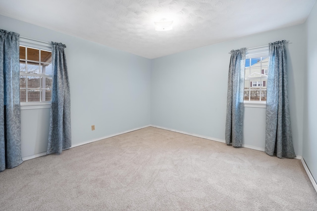 carpeted empty room featuring a textured ceiling