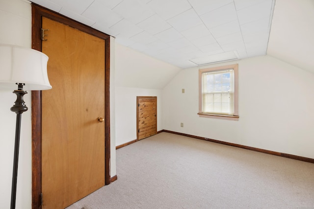 bonus room featuring lofted ceiling and light colored carpet