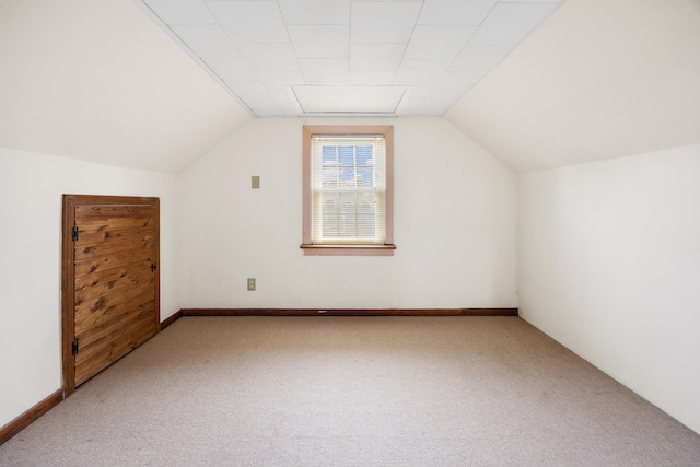 bonus room with lofted ceiling and carpet flooring