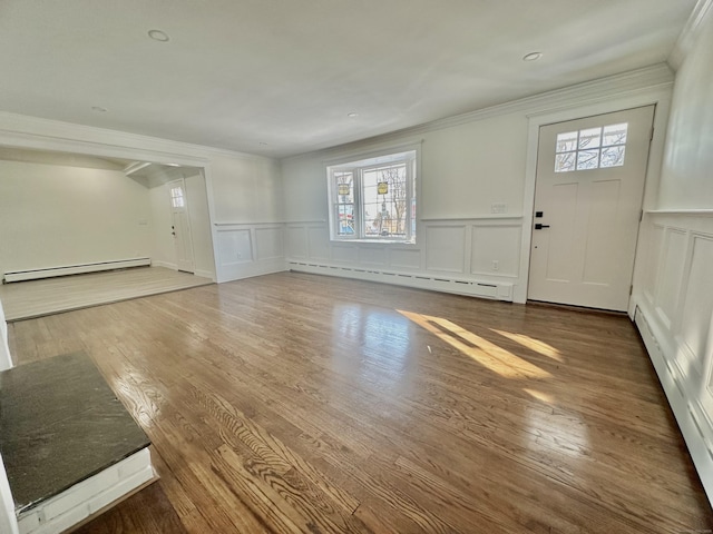 foyer entrance featuring hardwood / wood-style flooring, ornamental molding, and baseboard heating