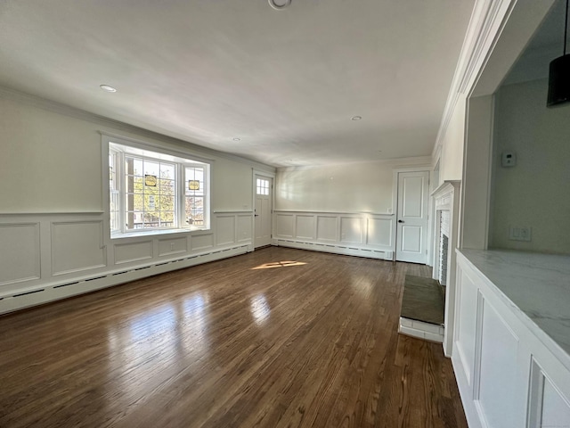 empty room featuring dark hardwood / wood-style flooring, crown molding, and baseboard heating