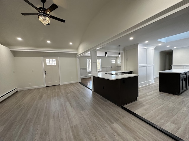 kitchen featuring lofted ceiling with skylight, plenty of natural light, a center island, and light wood-type flooring