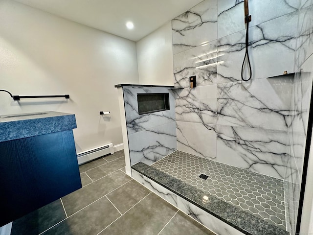 bathroom with tile patterned flooring, a shower, a baseboard heating unit, and vanity