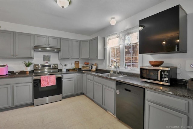 kitchen with appliances with stainless steel finishes, sink, and gray cabinetry