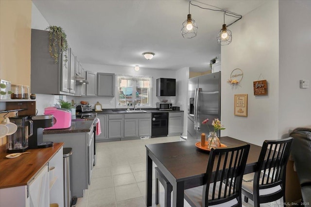 kitchen featuring stainless steel appliances, gray cabinetry, hanging light fixtures, and sink