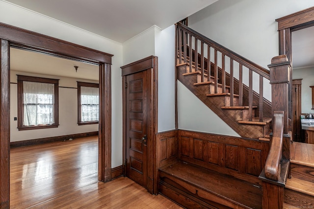 staircase featuring ornamental molding, baseboards, and wood finished floors