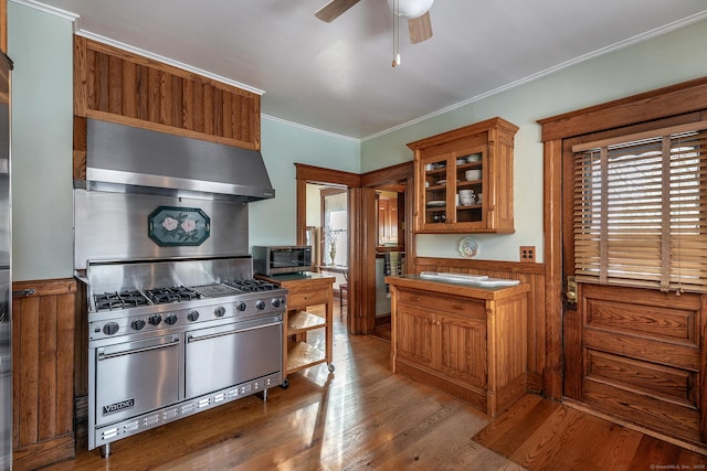 kitchen featuring dark wood-style floors, range hood, crown molding, appliances with stainless steel finishes, and ceiling fan