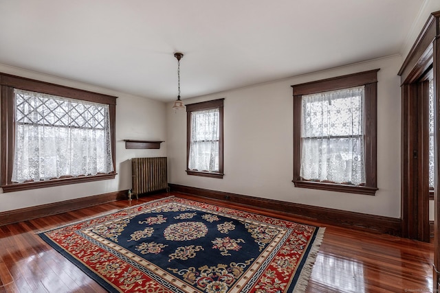 interior space featuring radiator, crown molding, baseboards, and hardwood / wood-style flooring