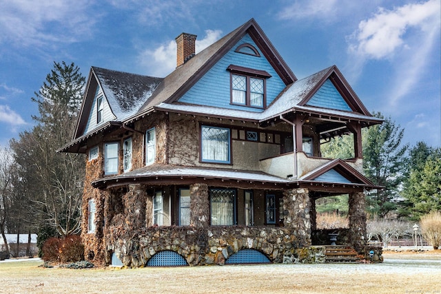 view of front of property featuring stone siding and a chimney