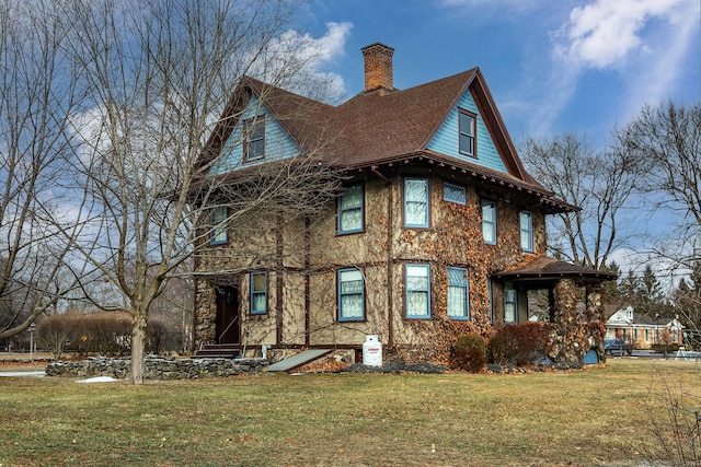 view of front facade with stone siding, a front lawn, and a chimney