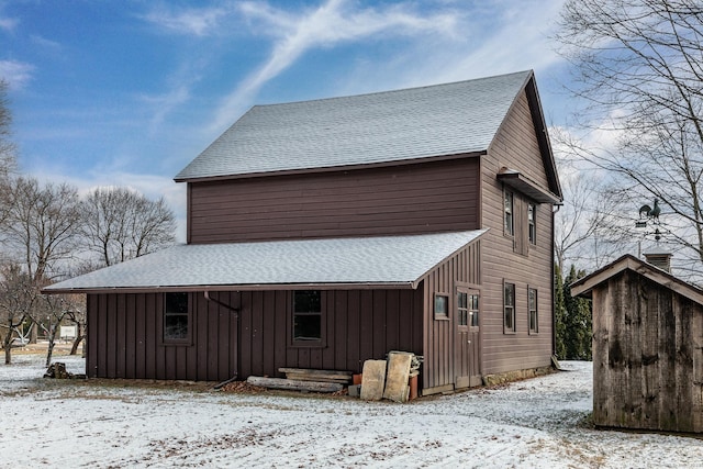 exterior space featuring board and batten siding and a shingled roof