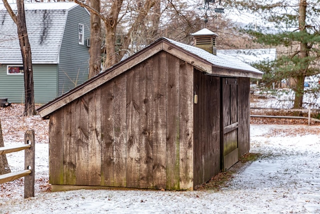 snow covered structure featuring an outbuilding