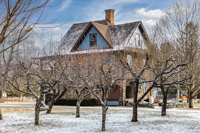 view of snowy exterior with a chimney